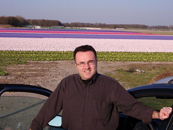 Vincenzo, con uno sfondo dei campi olandesi in fiore in Aprile-Maggio